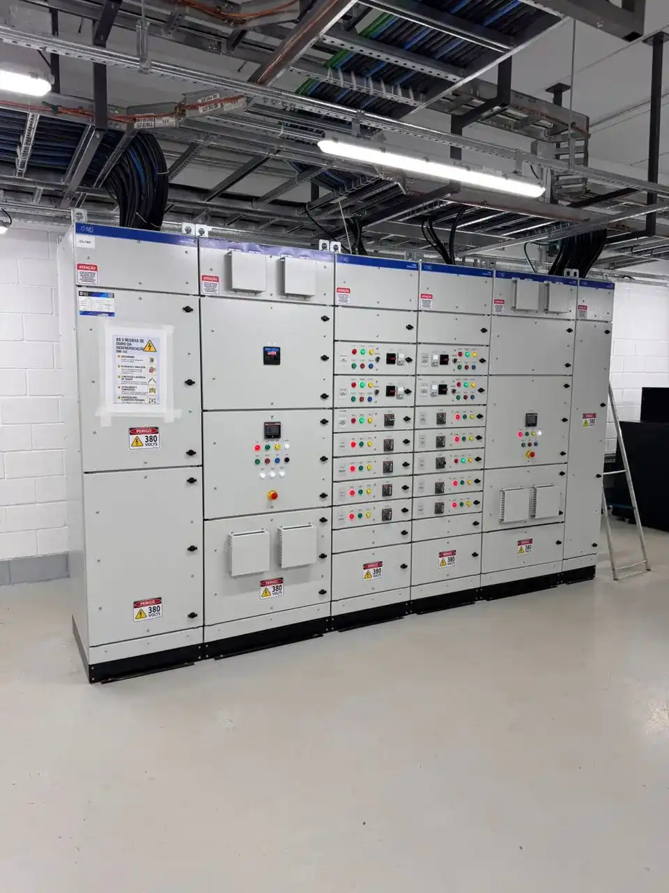 Painéis elétricos industriais com cabos e eletrocalhas em sala técnica