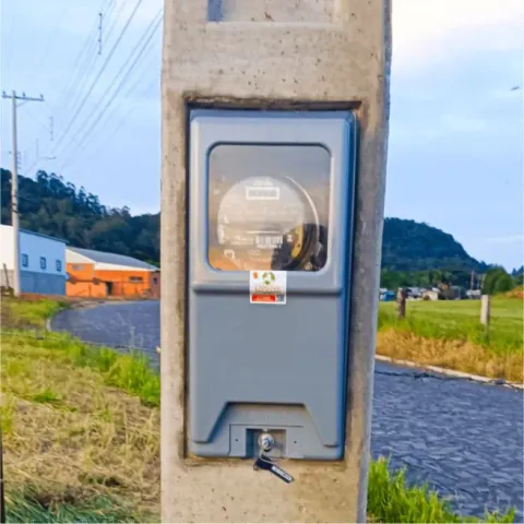 Medidor de energia em poste de concreto junto a uma estrada