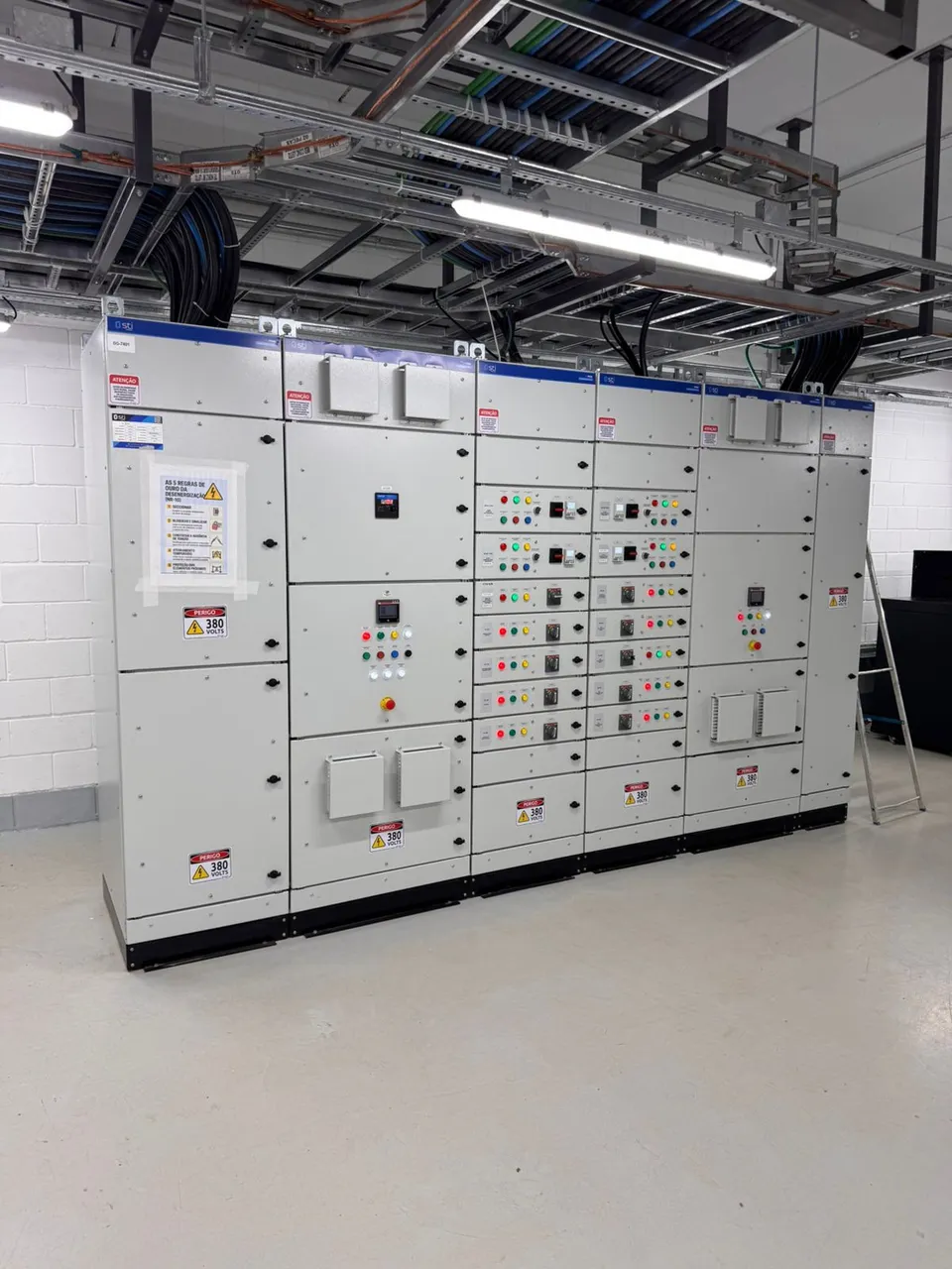 Painéis elétricos industriais com cabos e eletrocalhas em sala técnica