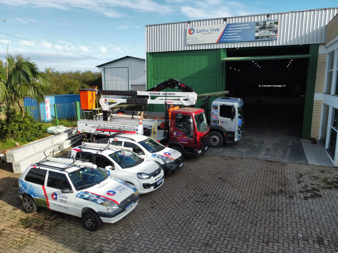 Vista aérea da frota de veículos diante do galpão do Grupo Linha Viva